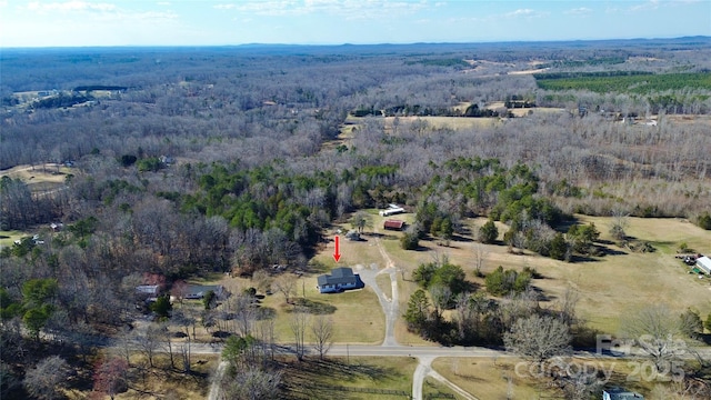 drone / aerial view featuring a wooded view