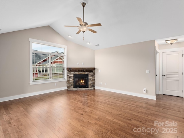 unfurnished living room with ceiling fan, hardwood / wood-style floors, lofted ceiling, and a fireplace