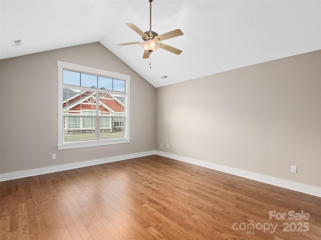 unfurnished room featuring hardwood / wood-style flooring, vaulted ceiling, and ceiling fan