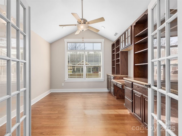 unfurnished office featuring ceiling fan, french doors, vaulted ceiling, and light hardwood / wood-style floors