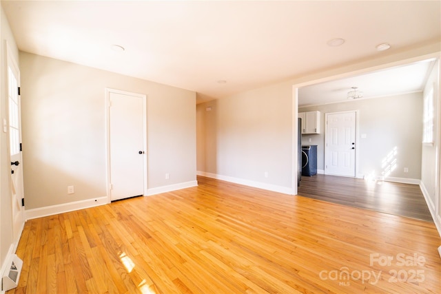 spare room featuring light hardwood / wood-style floors and washer / clothes dryer