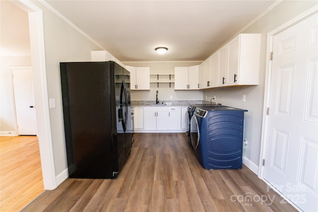 laundry area featuring dark hardwood / wood-style flooring, ornamental molding, sink, and washing machine and clothes dryer