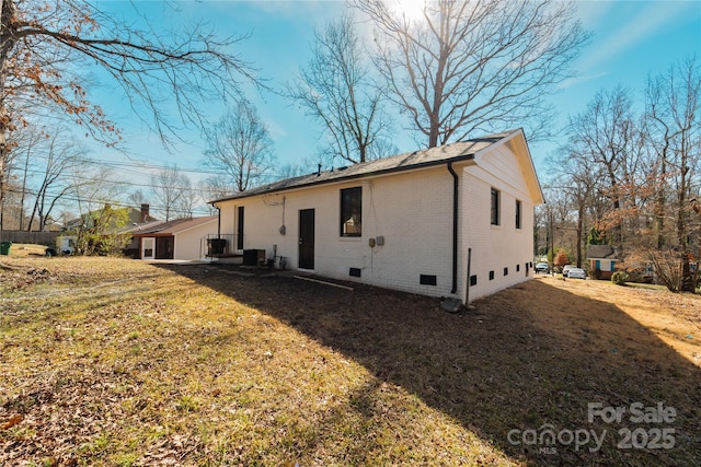 back of property featuring a lawn and central AC