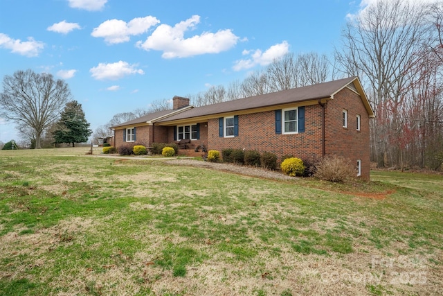 single story home with brick siding, a chimney, and a front lawn