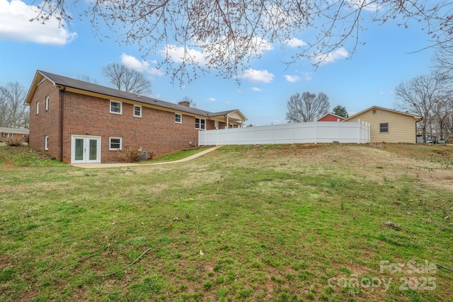 view of yard with fence and french doors