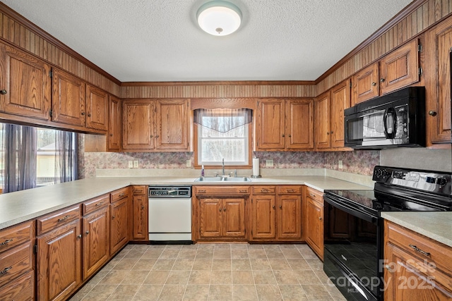 kitchen featuring black appliances, brown cabinetry, and a sink