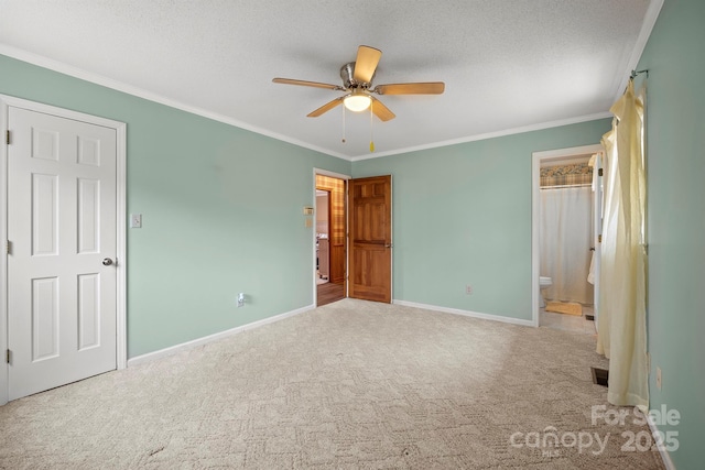 unfurnished bedroom with baseboards, connected bathroom, ornamental molding, a textured ceiling, and carpet flooring