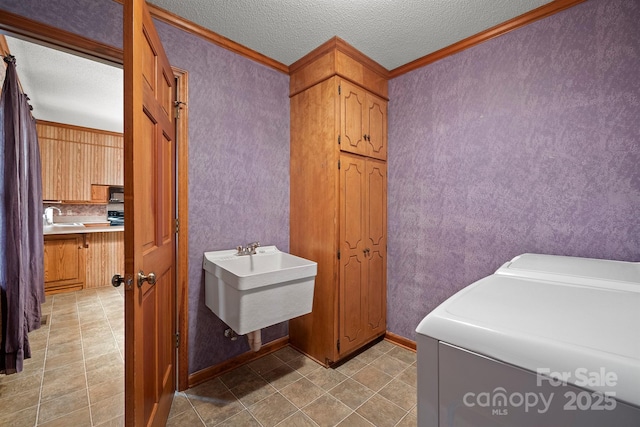 bathroom featuring a sink, a textured ceiling, and washer and dryer