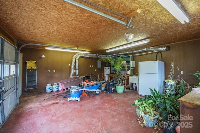 garage featuring freestanding refrigerator and a sink