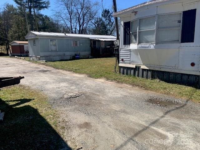 view of property exterior featuring driveway and a lawn