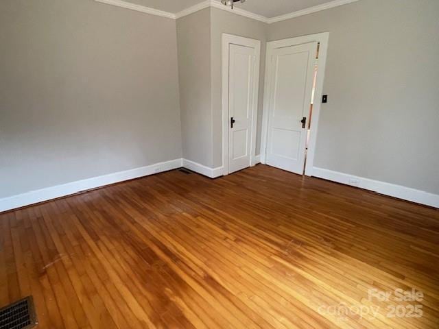 empty room featuring crown molding and hardwood / wood-style floors