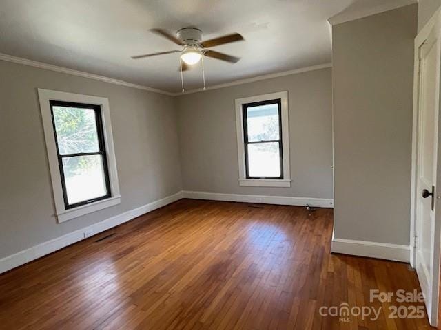 unfurnished room with dark hardwood / wood-style flooring, plenty of natural light, ornamental molding, and ceiling fan