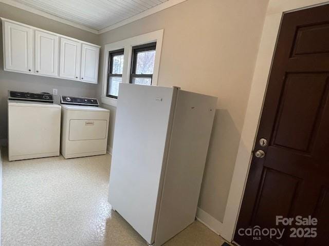 washroom with cabinets, crown molding, and washing machine and clothes dryer