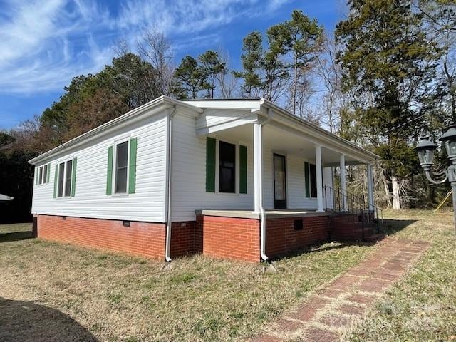 view of side of property with a lawn and a porch