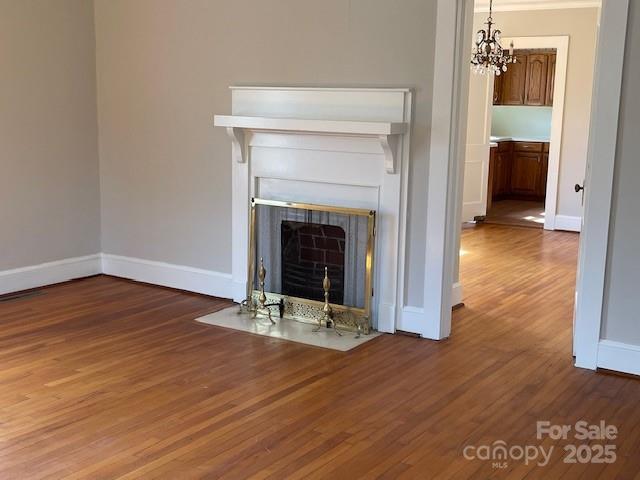 5135 Tucker Ave, Kannapolis, NC 28081 - detailed view of wood finished floors, a chandelier, and a fireplace with flush hearth