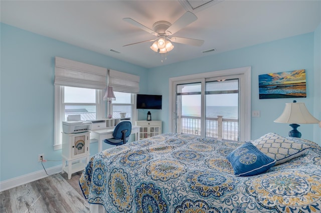 bedroom with wood finished floors, access to exterior, baseboards, and visible vents