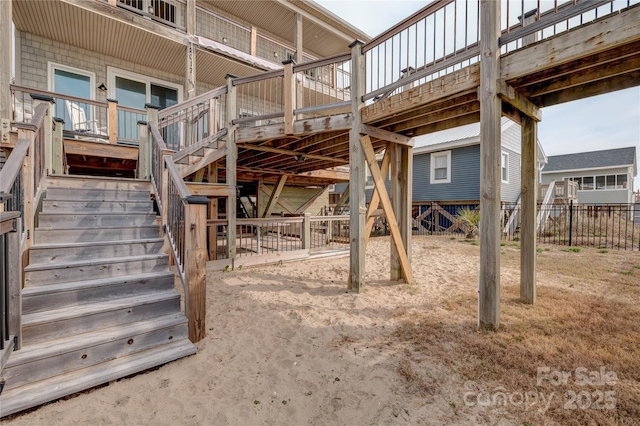 view of patio / terrace with a wooden deck, stairway, and fence