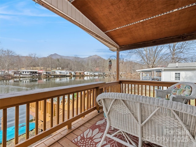 wooden deck with a water and mountain view