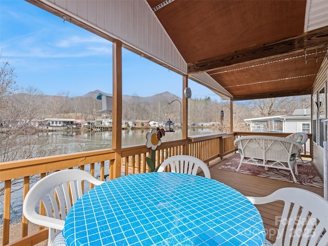 snow covered deck with a water and mountain view