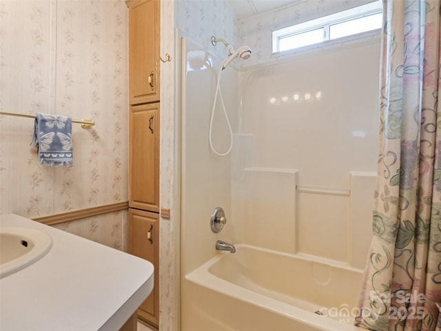 bathroom with shower / bathtub combination with curtain and sink