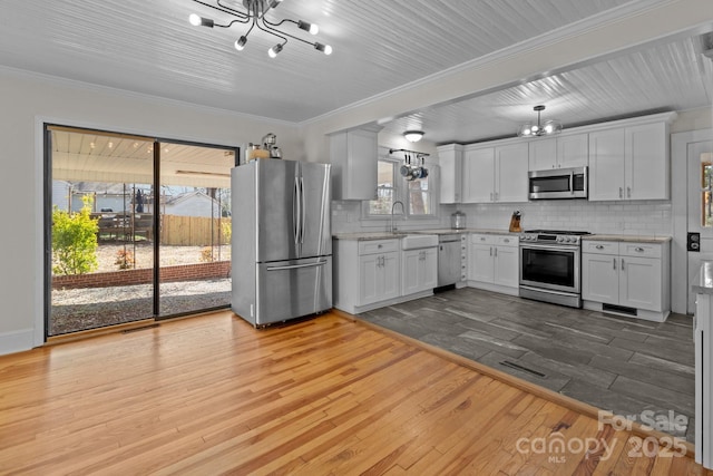 1216 Innis Ave, Kannapolis, NC 28081 - kitchen featuring decorative backsplash, appliances with stainless steel finishes, wood finished floors, and an inviting chandelier