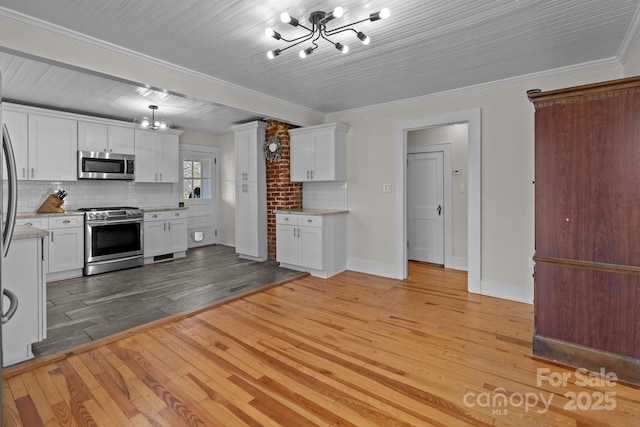 1216 Innis Ave, Kannapolis, NC 28081 - kitchen with an inviting chandelier, white cabinets, light wood-type flooring, and stainless steel appliances