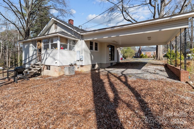 1216 Innis Ave, Kannapolis, NC 28081 - view of side of home featuring cooling unit, driveway, a sunroom, entry steps, and a carport