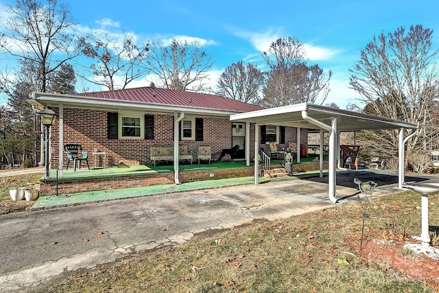 view of front of house featuring covered porch, a front yard, and a carport