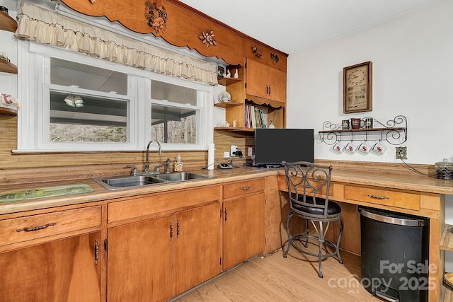 kitchen featuring light hardwood / wood-style flooring, sink, and built in desk