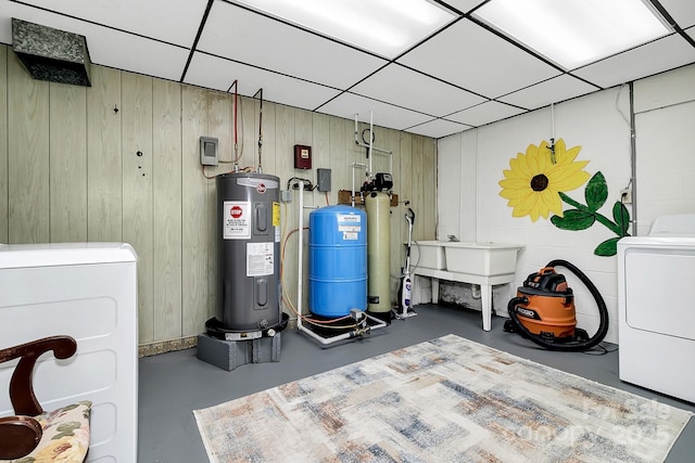 utility room with electric water heater and independent washer and dryer