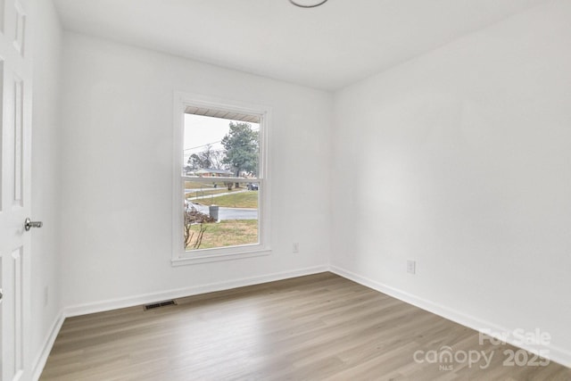 unfurnished room with hardwood / wood-style flooring