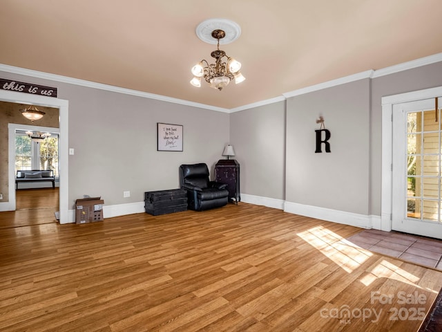 unfurnished room featuring baseboards, crown molding, a chandelier, and wood finished floors