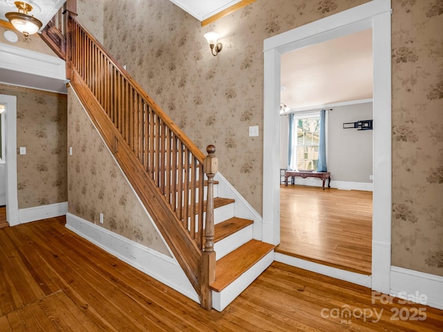 staircase featuring baseboards, hardwood / wood-style flooring, and wallpapered walls