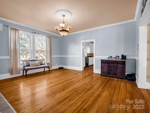 interior space with ornamental molding, hardwood / wood-style floors, baseboards, and an inviting chandelier