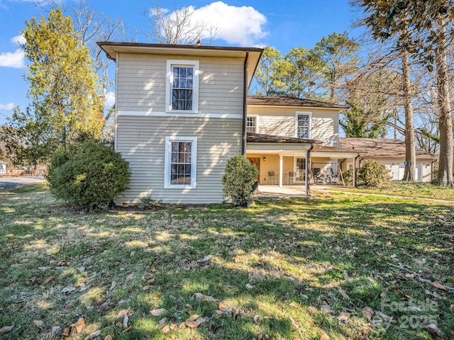 rear view of property featuring a lawn and a patio