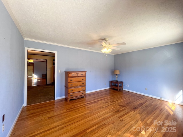 spare room with crown molding, a textured ceiling, ceiling fan, and wood finished floors