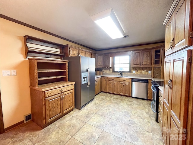 kitchen featuring tasteful backsplash, visible vents, appliances with stainless steel finishes, light countertops, and a sink