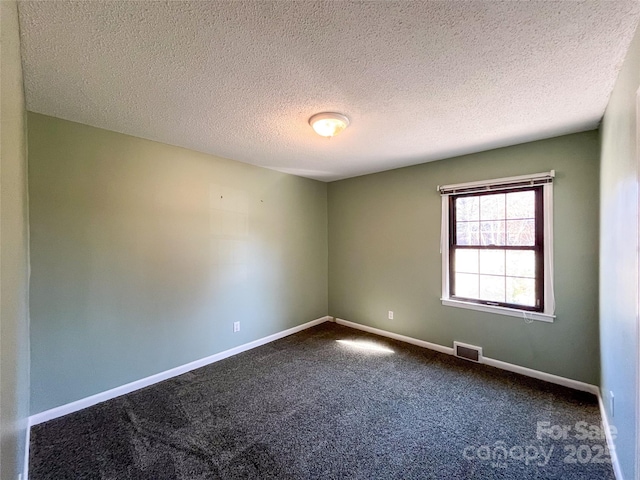 unfurnished room featuring carpet, visible vents, a textured ceiling, and baseboards