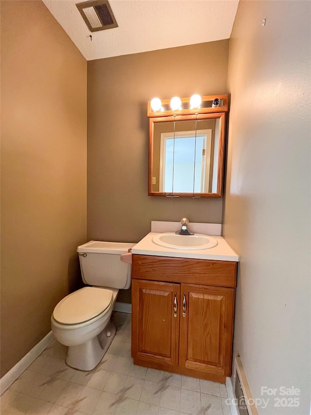 half bath with baseboards, visible vents, vanity, and toilet