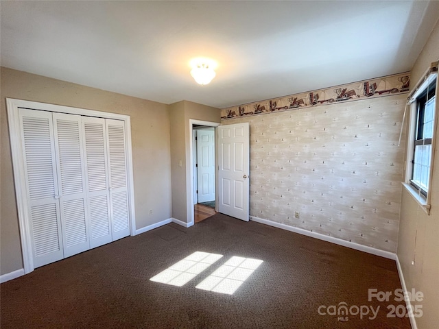 unfurnished bedroom featuring carpet, a closet, and baseboards