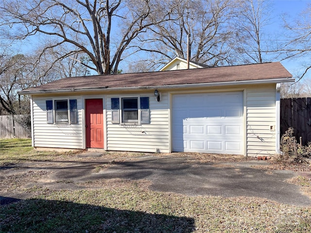 garage featuring dirt driveway and fence