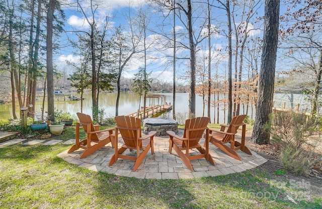 view of patio / terrace with a dock, a fire pit, and a water view