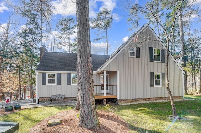 view of front of property with crawl space, a chimney, roof with shingles, and a front yard