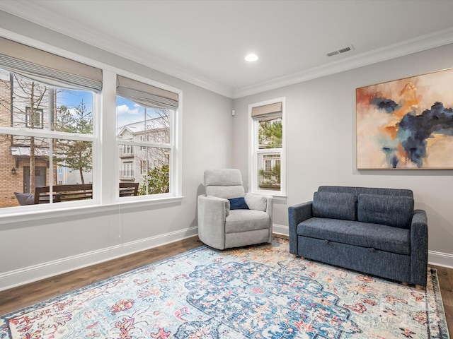 living area featuring ornamental molding, wood finished floors, visible vents, and baseboards