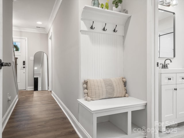 mudroom featuring crown molding, recessed lighting, dark wood-type flooring, a sink, and baseboards