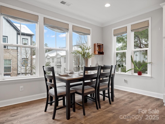 dining area with baseboards, visible vents, wood finished floors, crown molding, and recessed lighting