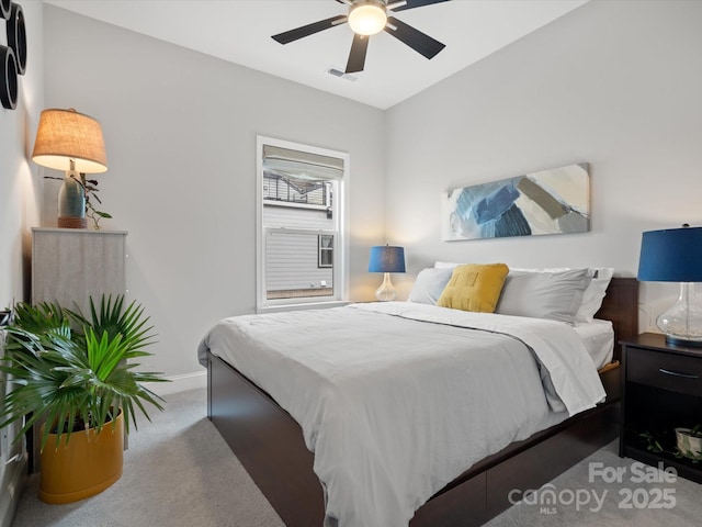 carpeted bedroom featuring a ceiling fan, visible vents, and baseboards