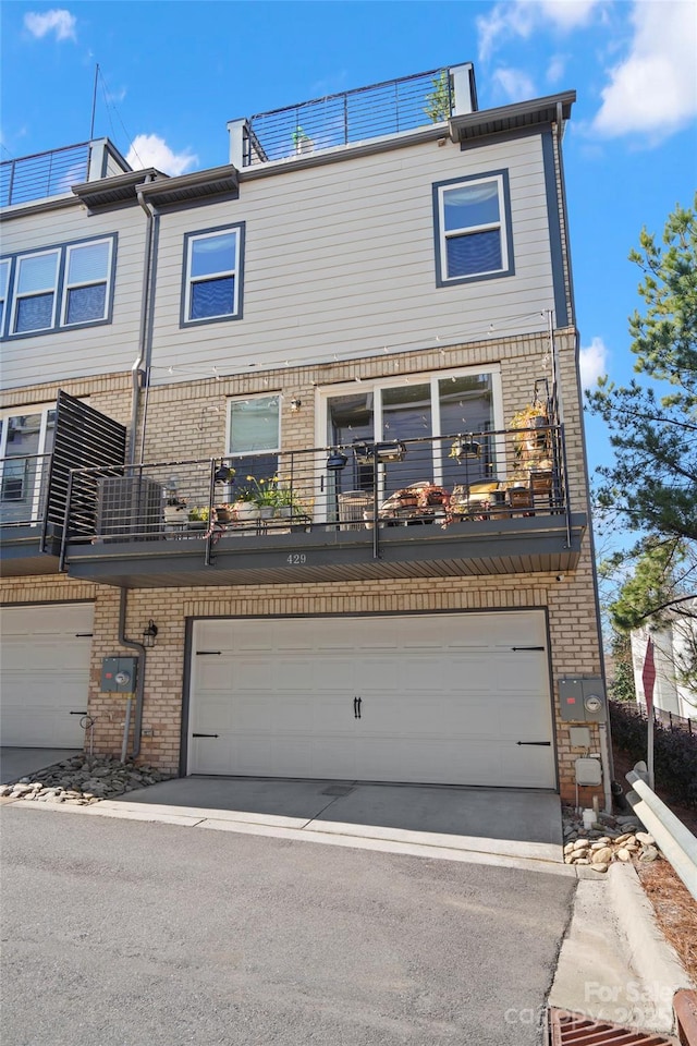 view of property featuring a garage and brick siding