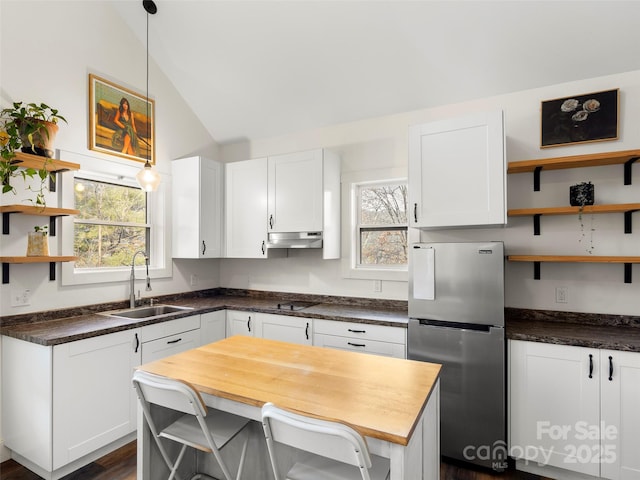 kitchen featuring sink, white cabinetry, stainless steel fridge, and a center island