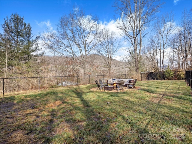 view of yard with an outdoor living space with a fire pit